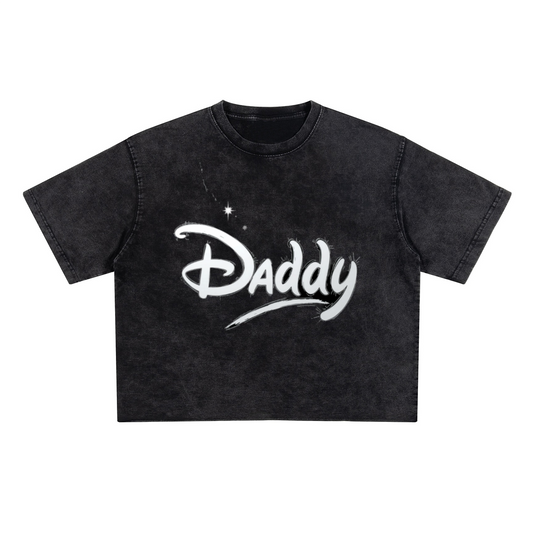 White crop top with the word 'Daddy' printed across the chest in a whimsical, Disney-inspired script. Soft cotton, gender-inclusive fit with a playful twist.