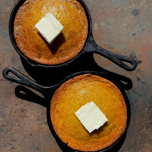 Honey butter cornbread baked in a cast iron skillet with brown sugar and cinnamon, served at a queer-owned restaurant in West Hollywood.