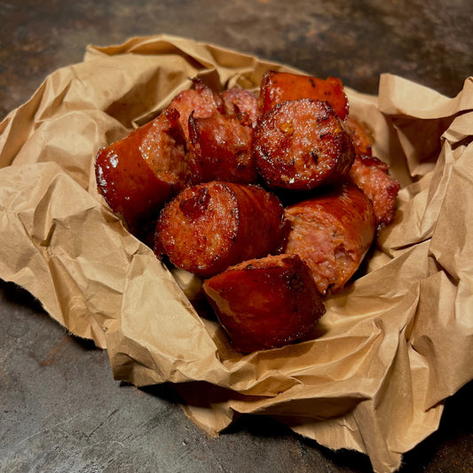 Smoked andouille sausage with Cajun spice, slow-cooked and served hot at a queer-friendly restaurant in West Hollywood.