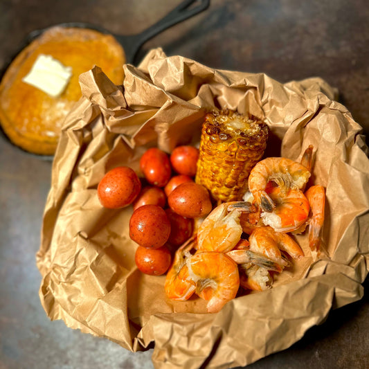 Snack-sized Cajun seafood with shrimp, corn, and potatoes served with sauce at a queer-friendly West Hollywood restaurant.