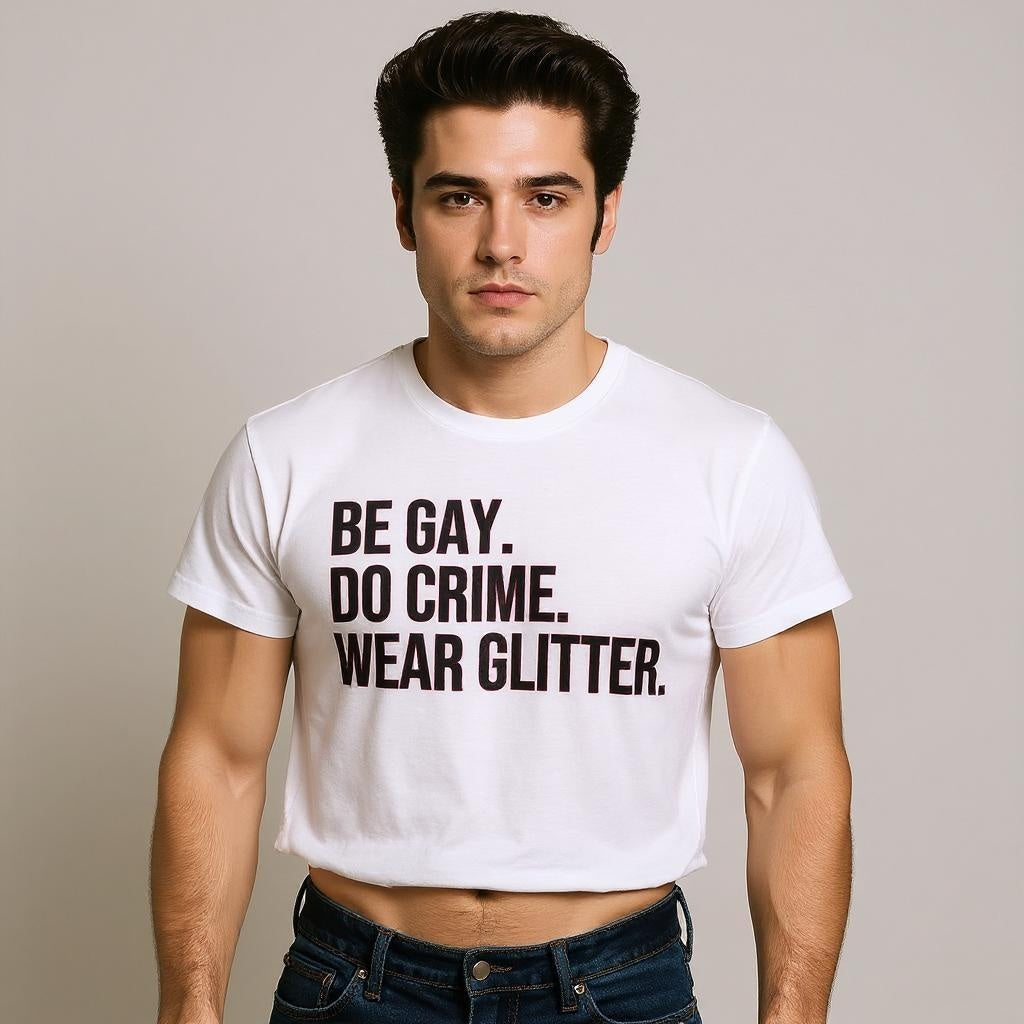 Man wearing a white t-shirt with text 'BE GAY. DO CRIME. WEAR GLITTER.' on a plain background