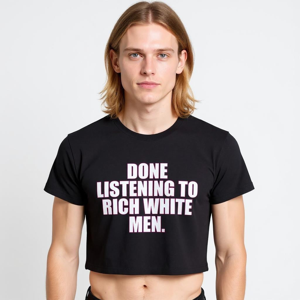 A model wearing a black crop top with bold pink and white text reading “Done Listening to Rich White Men,” showcasing queer streetwear, activist fashion, and gender-inclusive LGBTQ+ apparel.