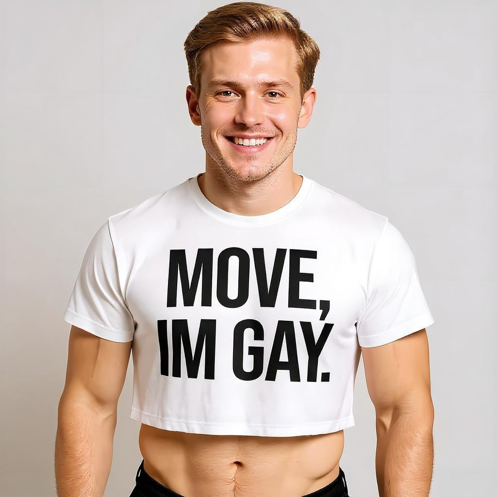 A man wearing a white cropped T-shirt with bold black text reading “MOVE, I’M GAY” centered on the front.