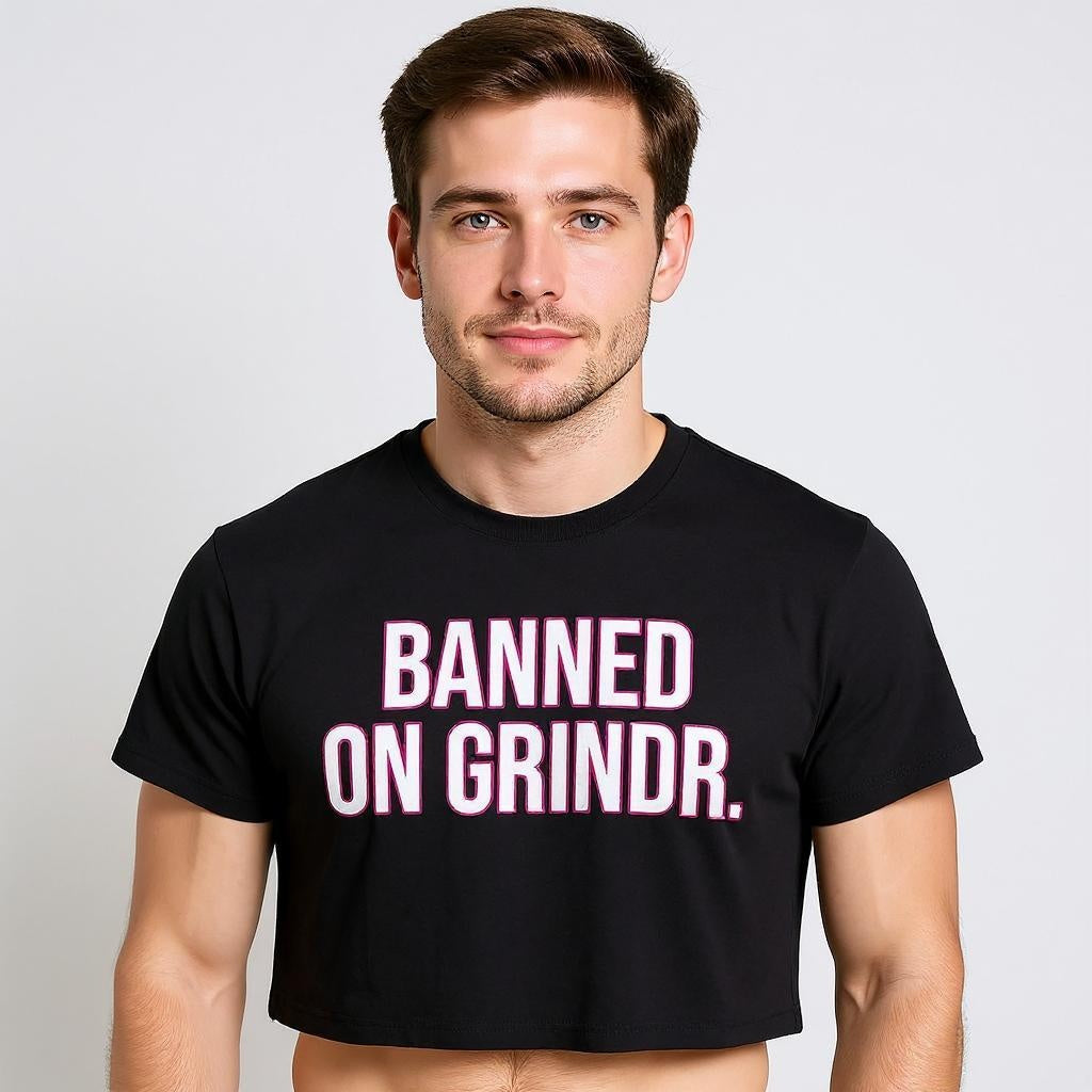 Man wearing a black t-shirt with 'BANNED ON GRINDR' text on a plain background