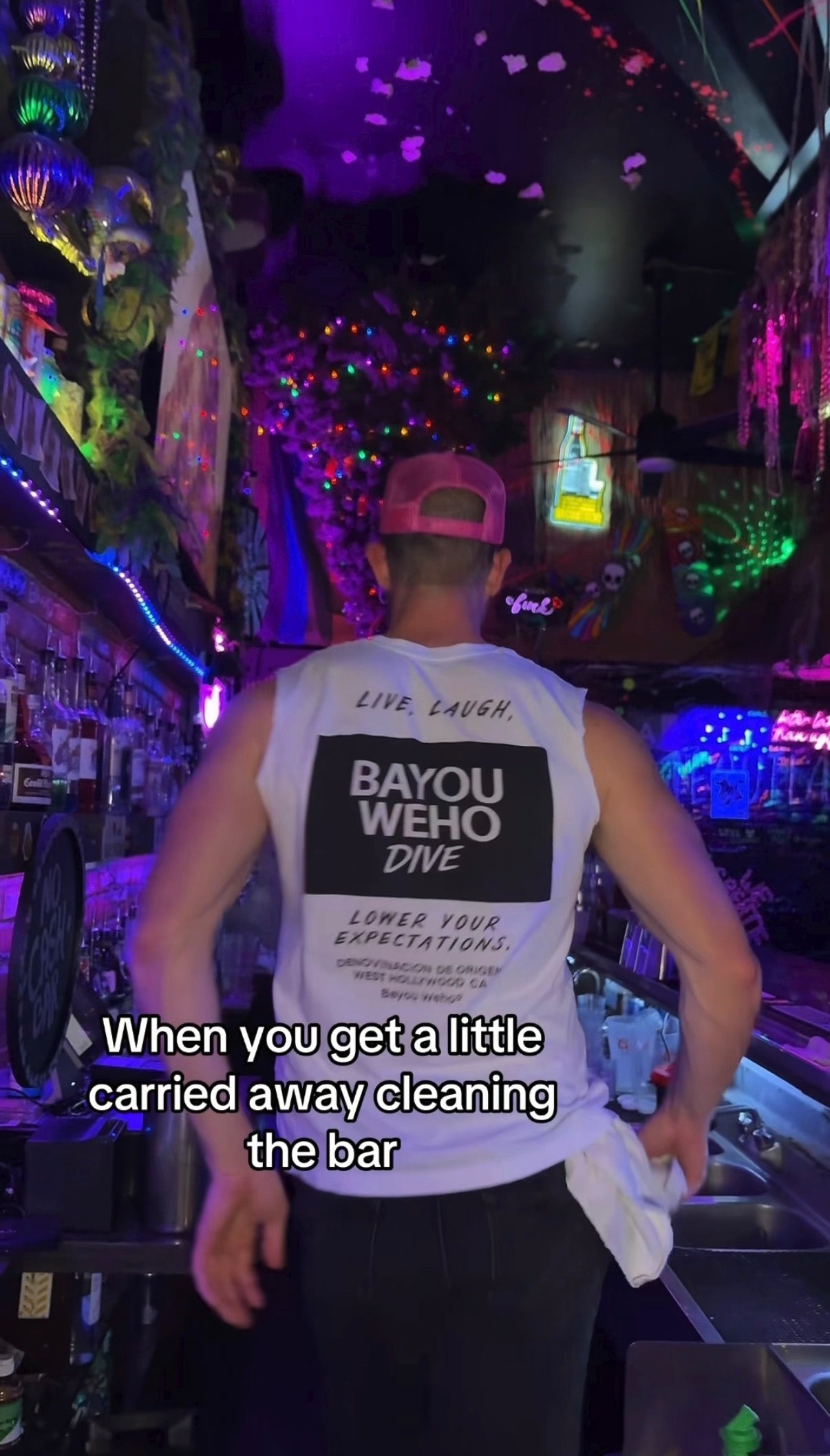 cheap bars in la shirt bayou weho dive bar white with black lettering in a neon Christmas tree dive bar in West Hollywood with a male model.