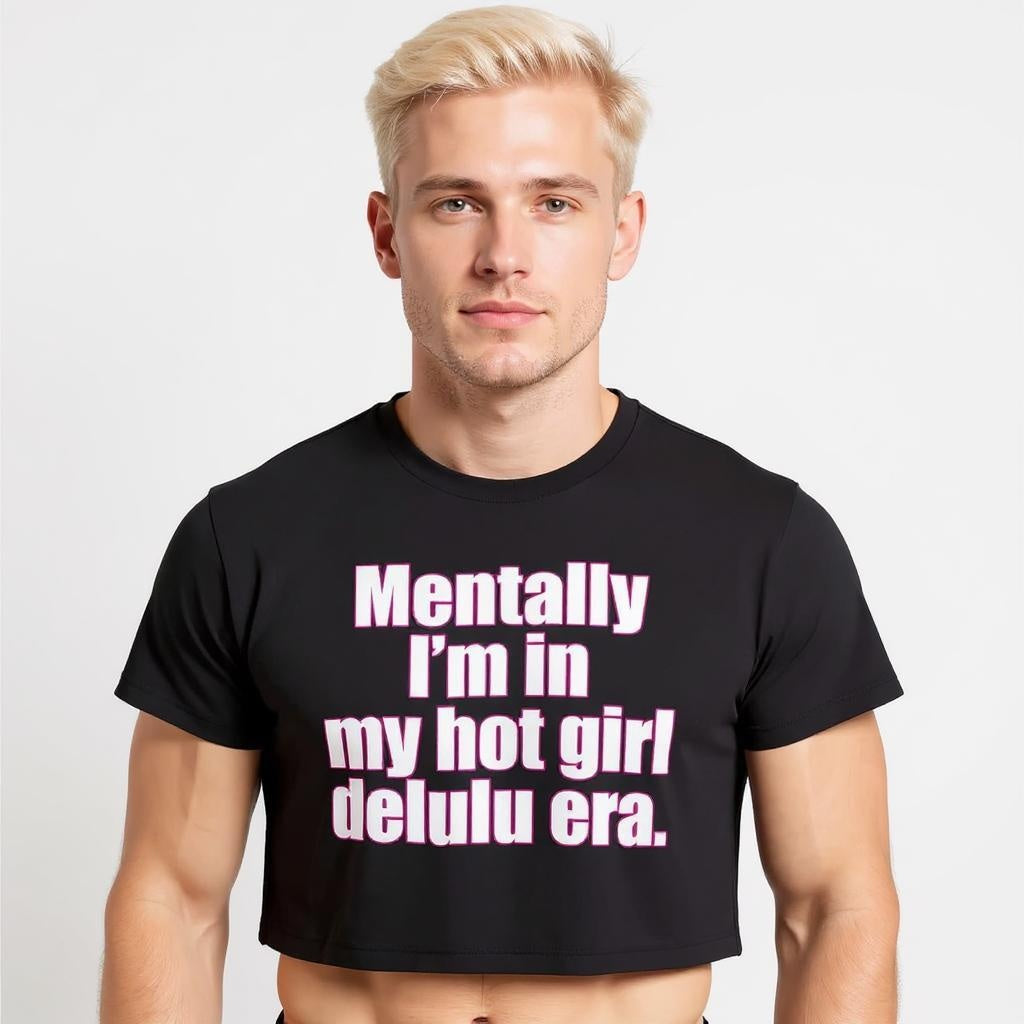 Model wearing a black crop top with bold pink and white text that reads “Mentally I’m in my hot girl delulu era,” representing queer humor, Gen Z streetwear, and viral TikTok fashion.