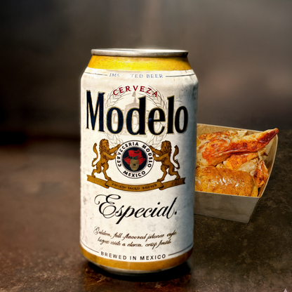 Modelo Especial beer can with a side of lobster roll on a textured surface for the best happy hour in weho bayou