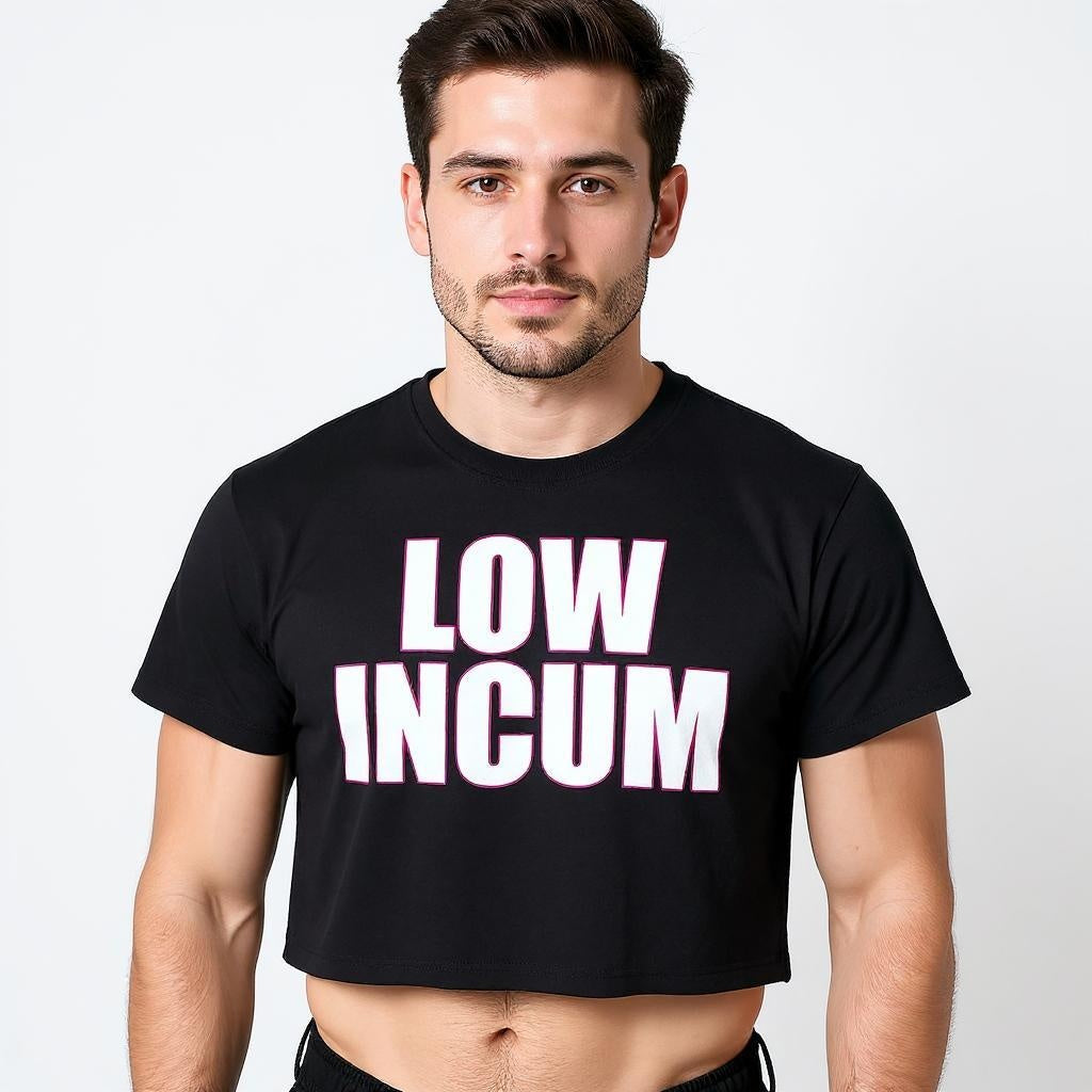 Confident man wearing a black gender-inclusive crop top with bold white and pink text that reads “LOW INCUM,” representing queer humor and LGBTQ+ streetwear culture.