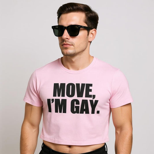 A confident model in a pink crop top with bold black text reading “MOVE, I’M GAY,” serving queer streetwear energy and body-positive LGBTQ+ fashion.