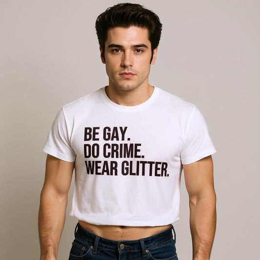 Man wearing a white t-shirt with text 'BE GAY. DO CRIME. WEAR GLITTER.' on a plain background