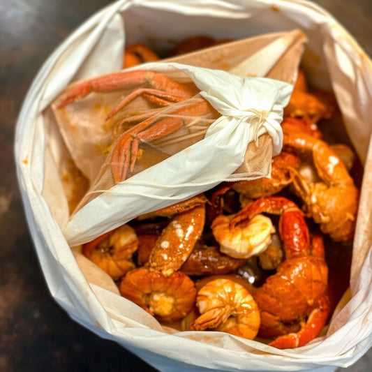 Seafood boil bag brunch catering with crawfish, shrimp, and Cajun sides—perfect for private events and parties searching for unique brunch catering near me.