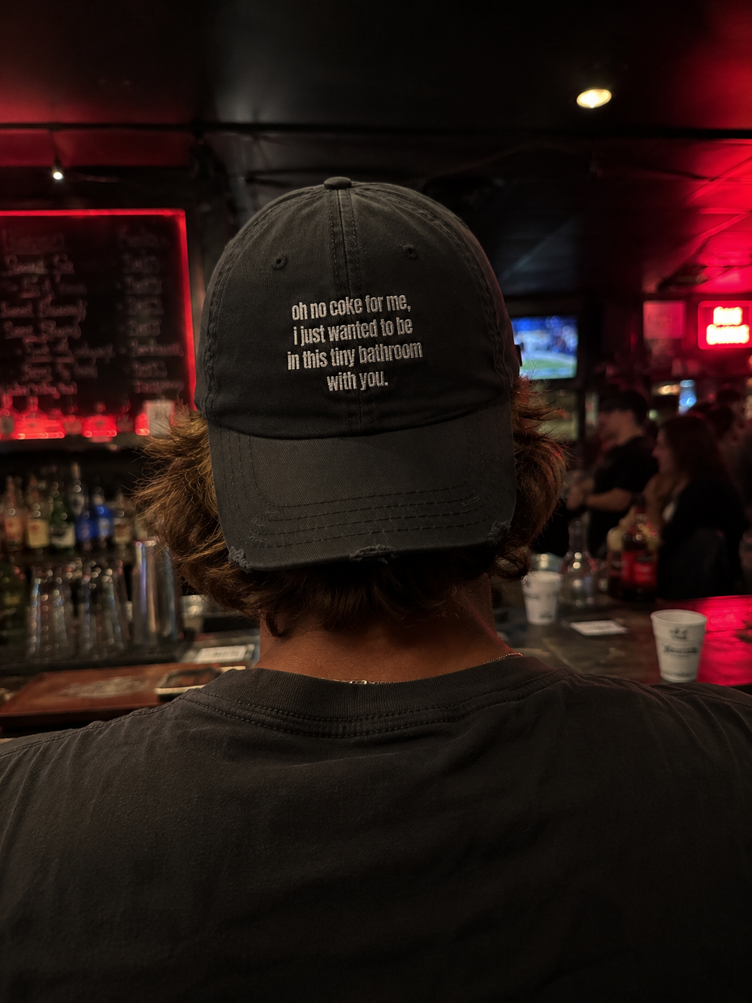 Person wearing a cap with text in a bar setting
