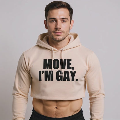 The model is wearing a beige crop hoodie with bold black text reading “MOVE, I’M GAY,” showcasing queer streetwear, gender-inclusive fashion, and unapologetic LGBTQ+ pride style.