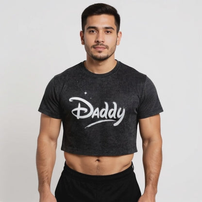 Model wearing a black vintage-style crop top with bold white “Daddy” text in a playful script, representing queer streetwear, gay pride fashion, and gender-inclusive LGBTQ+ apparel.