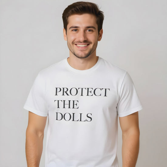Person wearing a black “Protect the Dolls” T-shirt—bold pro-drag, pro-trans message.