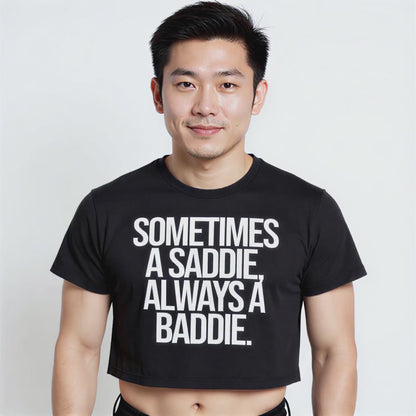 Person wearing a black crop top with bold white text reading “Sometimes a Saddie, Always a Baddie”—playful LGBTQ+ pride streetwear style.